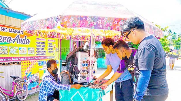 KECIPRATAN UNTUNG: Sejumlah wisatawan saat membeli buah tangan dari pelaku UMKM di Pulau Derawan.