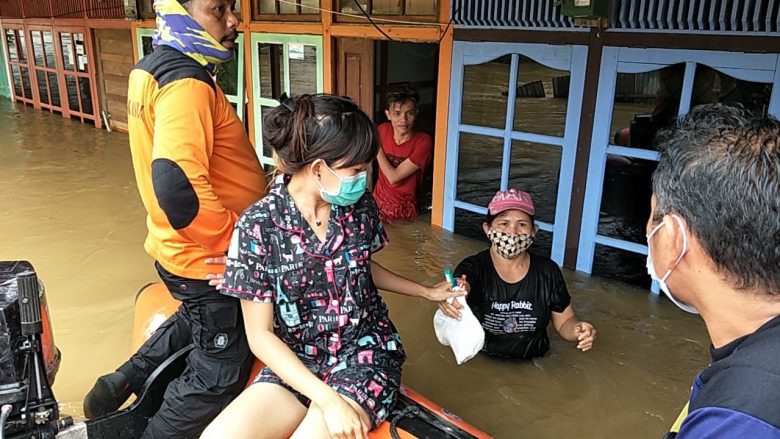 MENGUNGSI: Petugas BPBD Landak mengevakuasi korban banjir di Ngabang Kabupaten Landak. Warga meninggalkan rumahnya karena tinggi air telah mencapai atap di Kecamatan Kuala Behe, Sabtu (16/1).