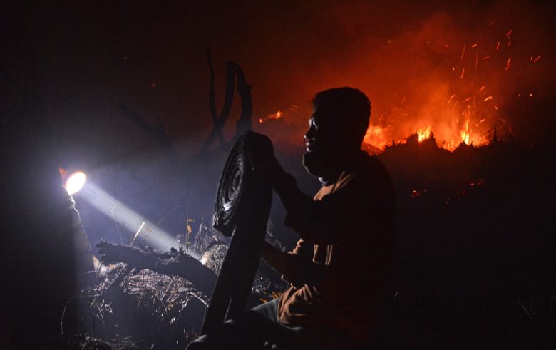 KEBAKARAN LAHAN : Kebakaran hutan dan lahan kembali terjadi di Kota Pontianak. Tampak salah satu pemadam dari BPBD Kota Pontianak sedang memadamkan api di salah satu lahan di Jalan Sepakat 2, Senin (22/2) malam. MEIDY KHADAFI/PONTIANAK POST