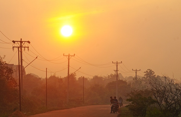 CUACA KERING: Warga melintas di Jalan Angkasa Pura II, Kubu Raya saat kondisi matahari memerah akibat asap kebakaran hutan dan lahan. Cuaca kering yang melanda Kalimantan Barat banyak menyebabkan kebakaran hutan dan lahan. HARYADI/PONTIANAKPOST