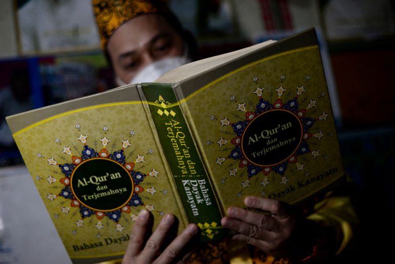 TERJEMAHAN QURAN: Jose Andreas Damsyik atau lebih dikenal dengan Muhammad Damanhuri sedang menunjukkan Alquran terjemahan dalam bahasa Dayak Kanayant. ARIEF NUGROHO/PONTIANAK POST