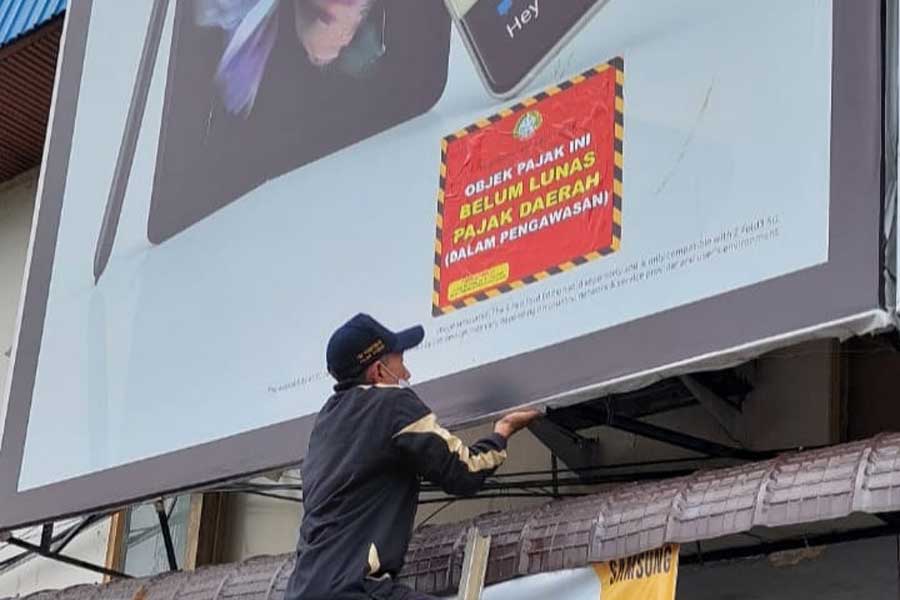 DISEGEL: Petugas melakukan penyegelan terhadap sejumlah papan reklame yang belum melunasi pajaknya. PROKOPIM UNTUK PONTIANAK POST