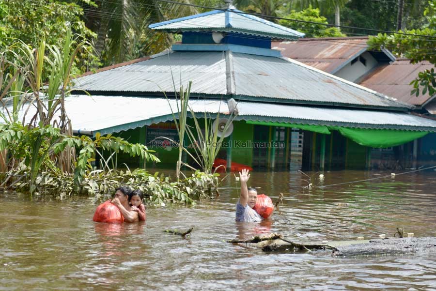 BANJIR TERPARAH: Sejumlah warga melewati Jalan Lintas Melawi yang terendam banjir sejak 24 Oktober hingga akhir November 2021. Banjir di Sintang ini disebut-sebut sebagai banjir yang terparah sejak tahun 1960-an. Selama 2021, bencana tak henti-hentinya me