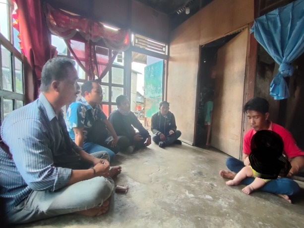 TANPA: Qori dipangku orangtuanya saat ditemui awak media di kediamannya. Dia terlahir tanpa tempurung kepala. (Wahyu/Pontianak Post)