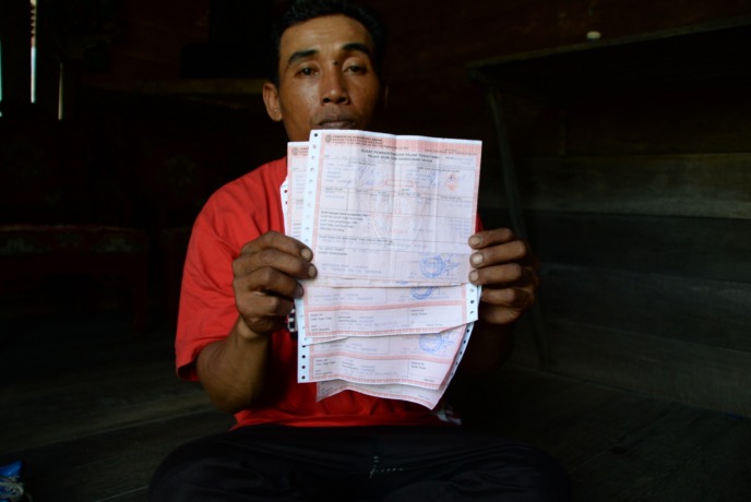 BUKTI PAJAK: Abdul Hadi, Ketua RT Dusun Kopiang memperlihatkan Surat Pemberitahuan Pajak Terhutang (SPPT) Pajak Bumi dan Bangunan (PBB). ARIEF NUGROHO/PONTIANAK POST