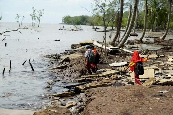 Sejumlah anak-anak berjalan melintasi jalan umum yang rusak akibat abrasi air laut di Desa Kuala Karang, Kecamatan Teluk Pakadai, Kabupaten Kubu Raya, Kamis (7/9). (ARIEF NUGROHO/PONTIANAK POST)