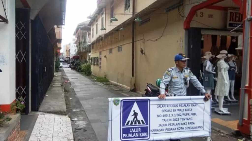 SOSIALISASI: Petugas Dishub Kota Singkawang Pasang Plang Larangan bagi kendaraan bermotor untuk melewati koridor/lorong di Kawasan Pusaka Kota. (ist)