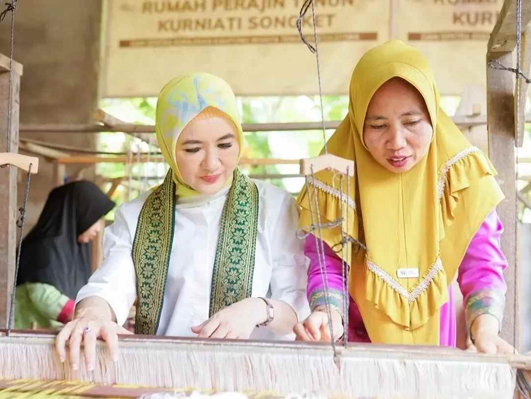 Direktur Utama Pertamina, Nicke Widyawati belajar menenun didampingi Kurniati. Orang nomor satu di Pertamina ini berkunjung ke Kampung Tenun Khatulistiwa Pontianak pada Sabtu (2/9). (@kanun_khatulistiwa for Pontianak Post)