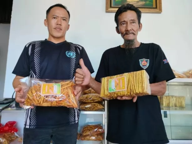 STIK KELADI: Kasbi (62) dan anaknya Juhardi (43) menunjukan produk Stik Keladi Enggang Gading milik mereka. Dalam sehari setidaknya setengah ton talas habis diproduksi di pabrik mini mereka, Jl Trans Kalimantan, Sui Ambawang, Kubu Raya. (ARISTONO/PONTIANA