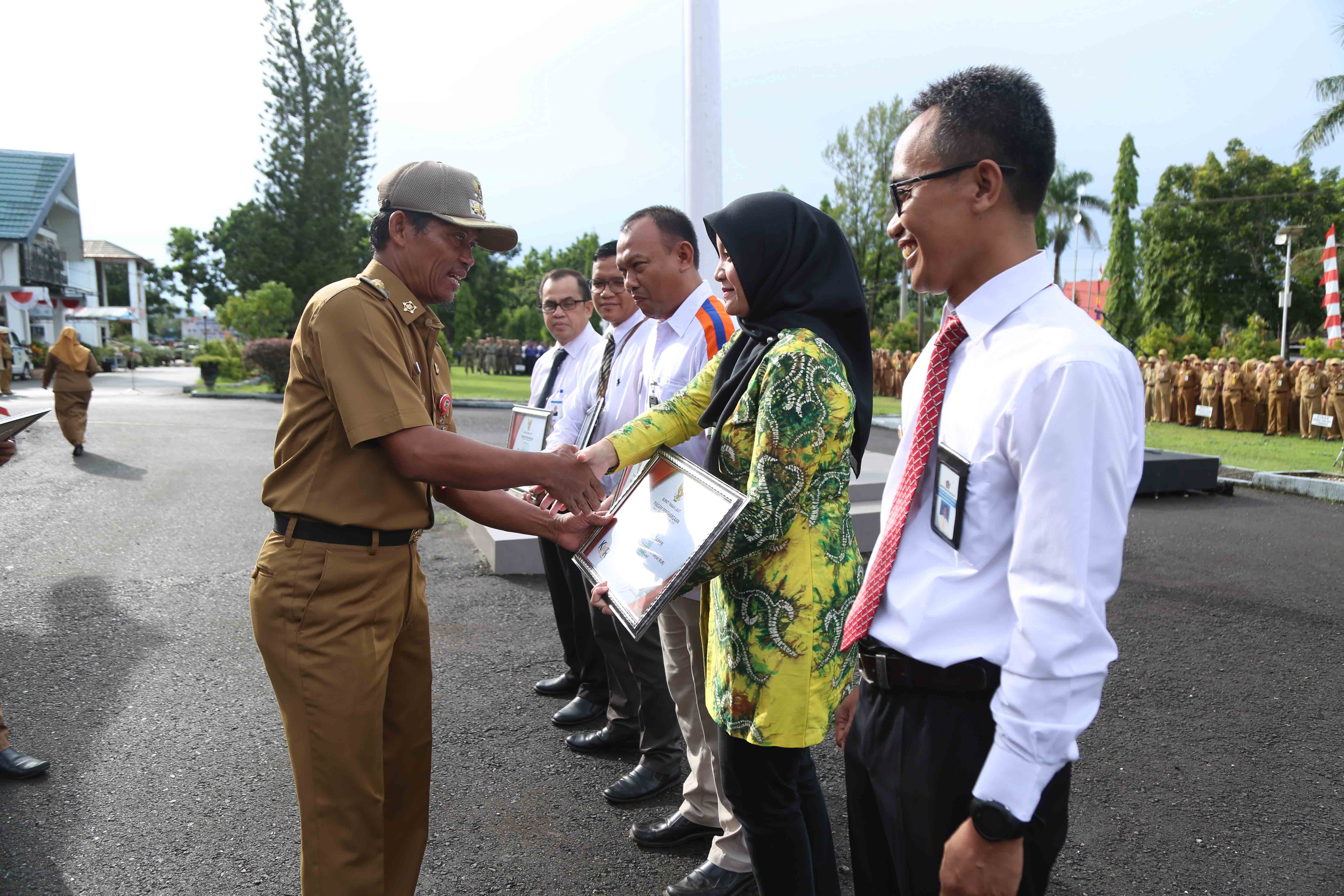 PENGHARGAAN: Bupati Tala Sukamta menyerahkan penghargaan kepada stakeholder yang terlibat dalam penyaluran KUR.