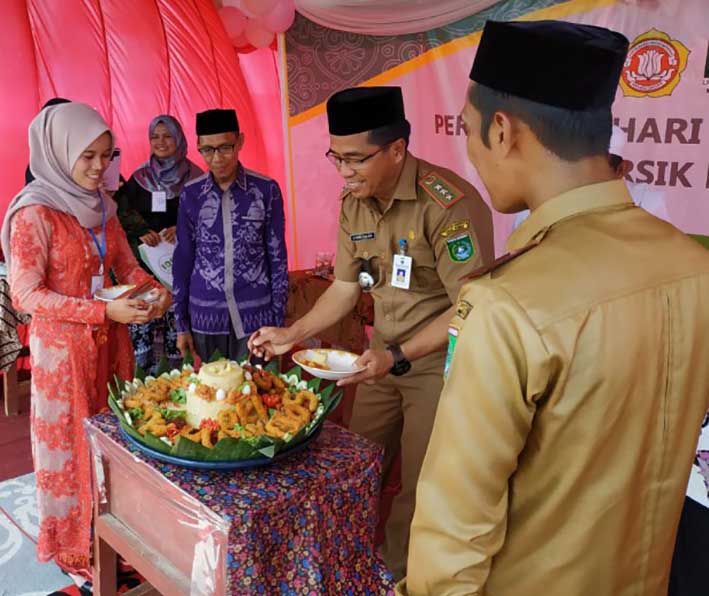 POTONG TUMPENG: Camat Batulicin H Yamani memotong nasi tumpeng pada perayaan HUT Desa Kersik Putih ke- ke-105 tahun 2019. | Foto: Karyono/Radar Banjarmasin