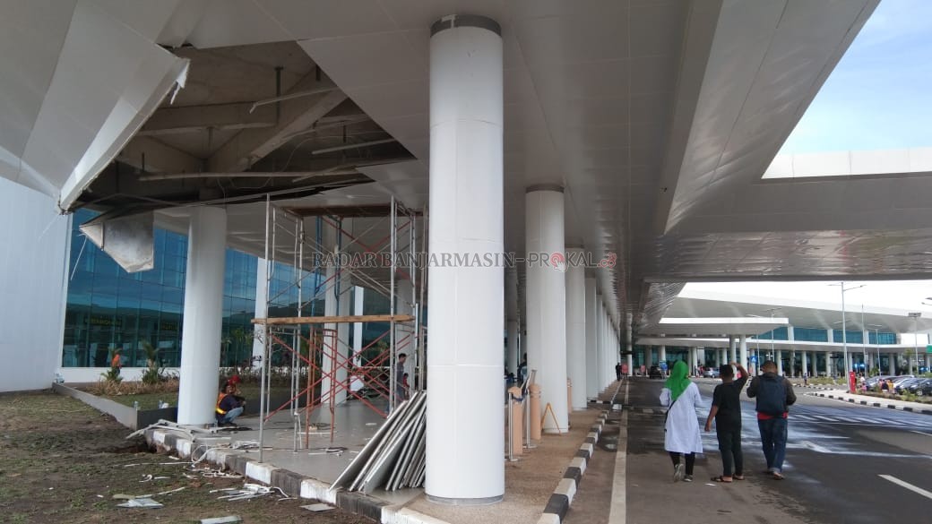 PERBAIKAN:  Para pekerja saat memperbaiki plafon Bandara Internasional Syamsudin Noor, kemarin. Sebelumnya, plafon tepat di ujung selasar terminal keberangkatan penumpang ini robek hingga 15 meter persegi, usai diterjang hujan deras Minggu (29/12) lalu. |