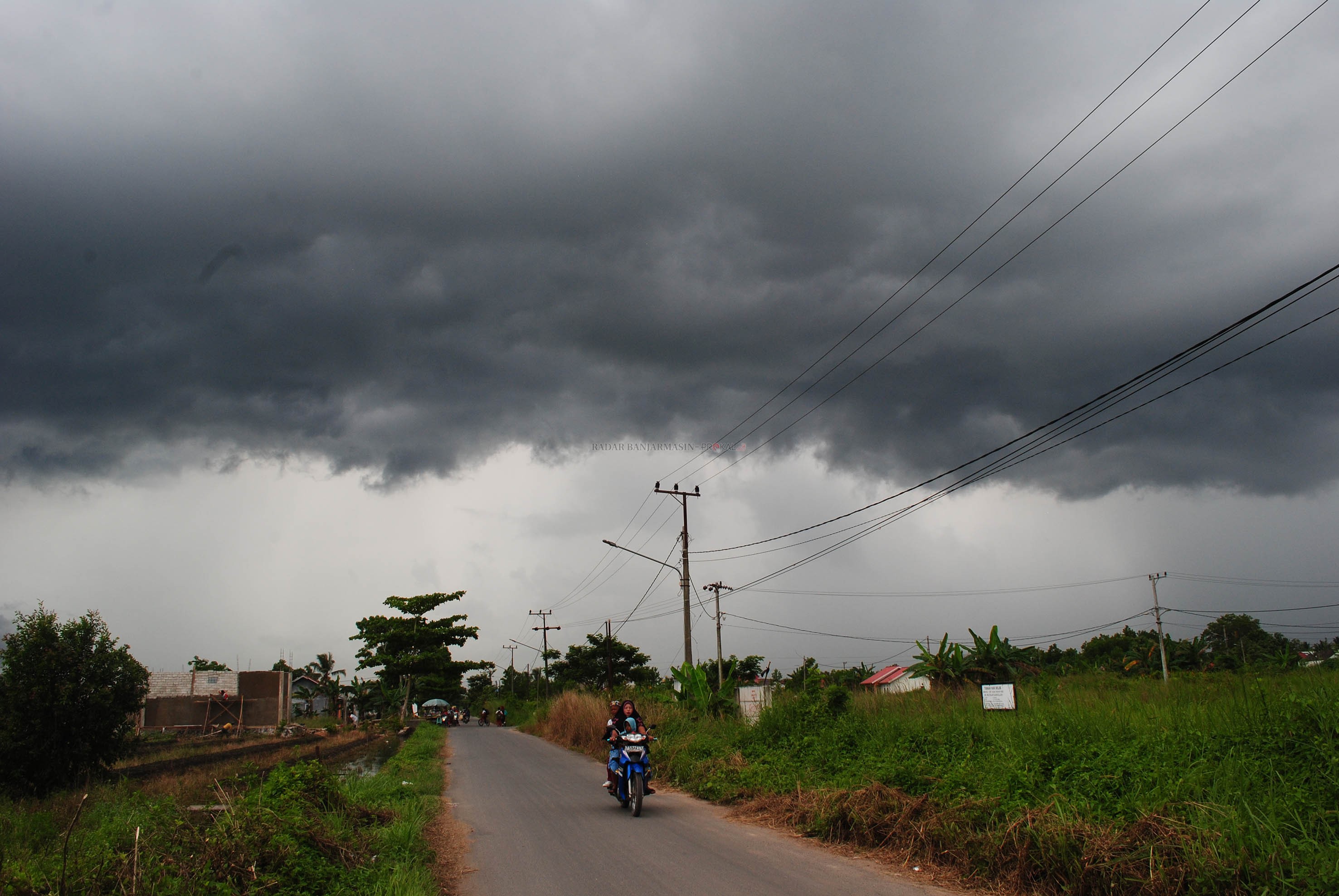 WASPADA CUACA EKSTREM: Awan hitam saat menyelimuti kawasan Landasan Ulin, Banjarbaru, Rabu (8/1) tadi. Masyarakat diminta waspada, karena Stasiun Meteorologi Kelas II Syamsudin Noor kembali mengeluarkan peringatan dini cuaca ekstrem di Banua. FOTO: SUTRIS