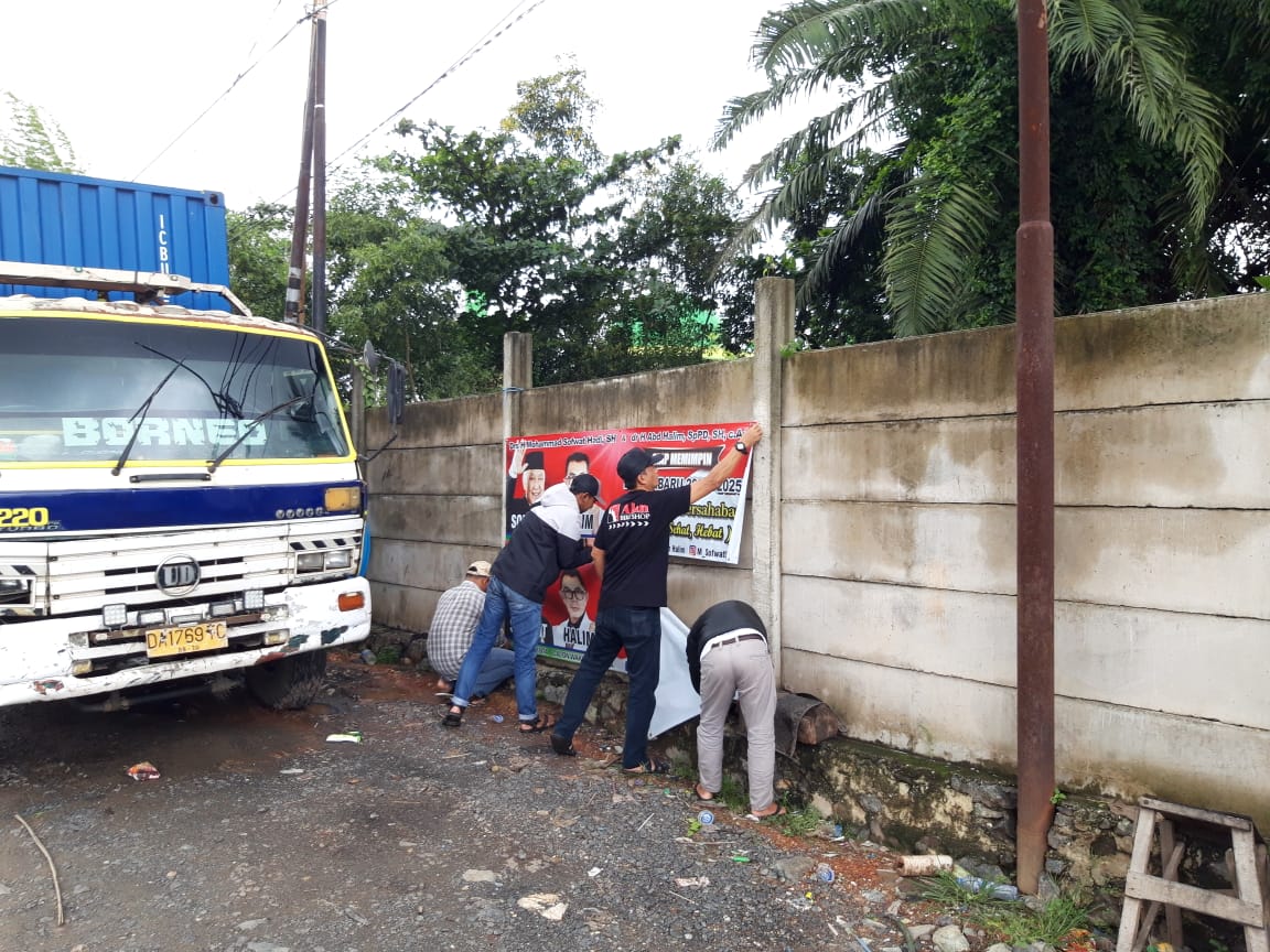 DICOPOT: Tim penertiban dari BP2RD Kota Banjarbaru menertibkan reklame milik pasangan Sofwat Hadi dan dokter Abdul Halim lantaran belum memenuhi kewajiban membayar pajak reklame. | Foto: BP2RD Banjarbaru for Radar Banjarmasin