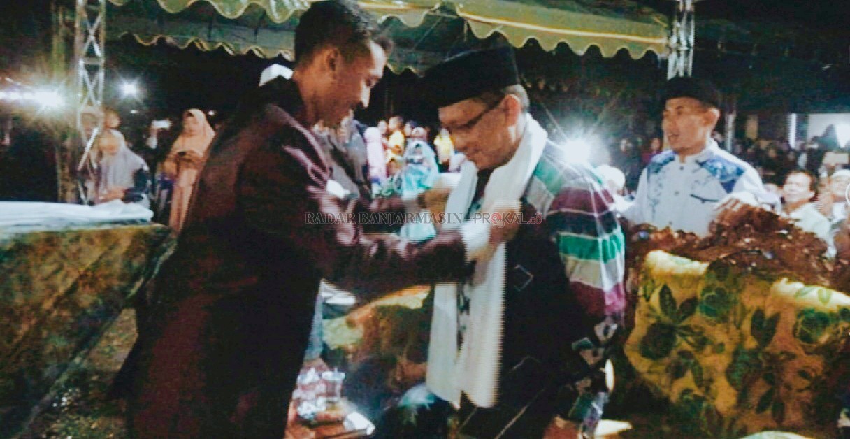 MOMEN: Panitia Nafis III Ponpes Nurul Amin Alabio saat mengalungkan sorban ke Asisten I Setda HSU Ir H Supomo saat mewakili Bupati membuka kegiatan Nafis III di Kecamatan Sungai Pandan. | Foto: Humas Pemkab HSU untuk Radar Banjarmasin