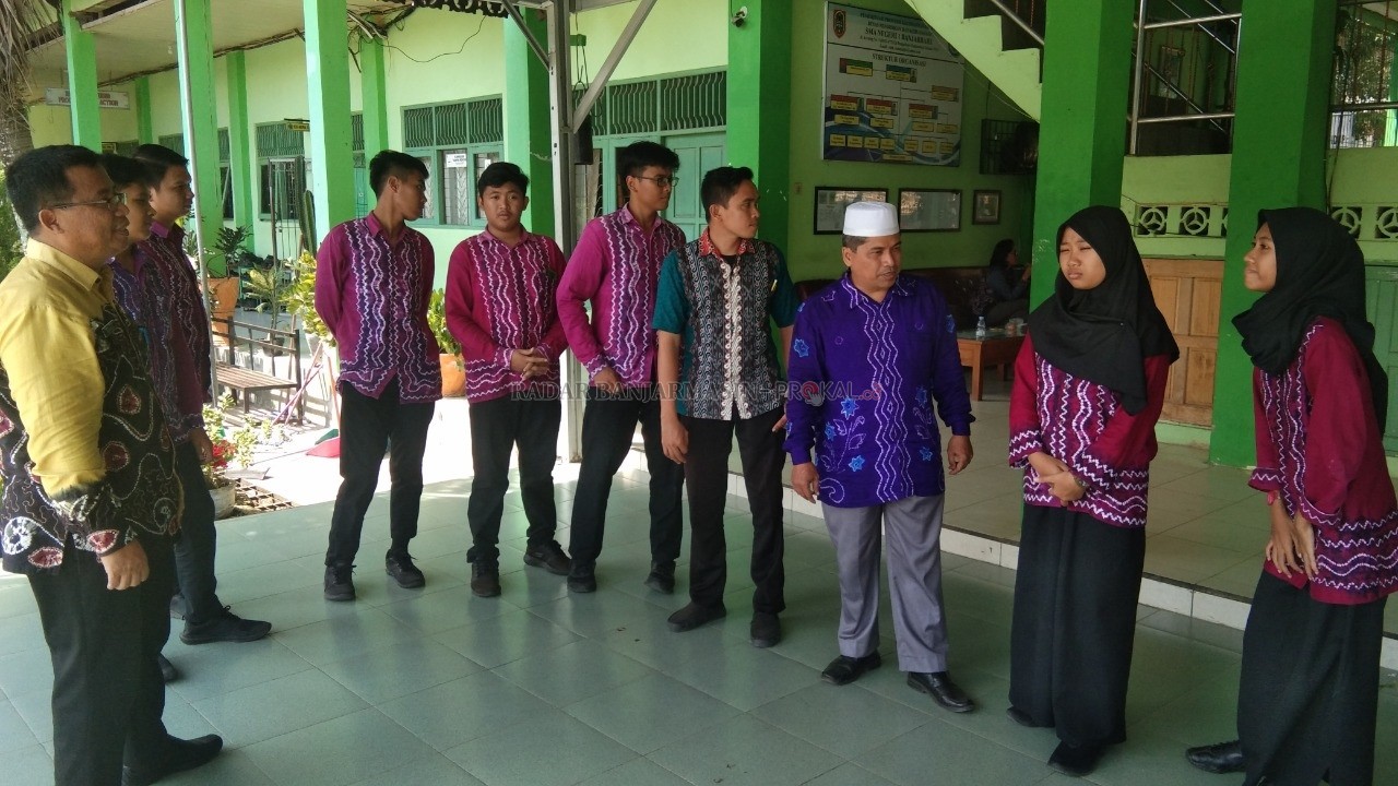 AKRAB: Guru honorer di SMAN 1 Banjarbaru, Bahrani (tiga dari kanan) bersama Kepala SMAN 1 Banjarbaru, Eko Sanyoto (ujung kiri) saat berbincang dengan para siswa dan siswi mereka, kemarin. | FOTO: SUTRISNO/RADAR BANJARMASIN