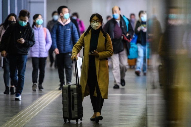 KETAT: Penumpang memakai masker pelindung saat tiba dari Shenzhen ke Hong Kong. Mahasiswa asal Tabalong yang pulang mengatakan mereka melewati setidaknya empat kali scanning. | Foto: Anthony WALLACE/AFP