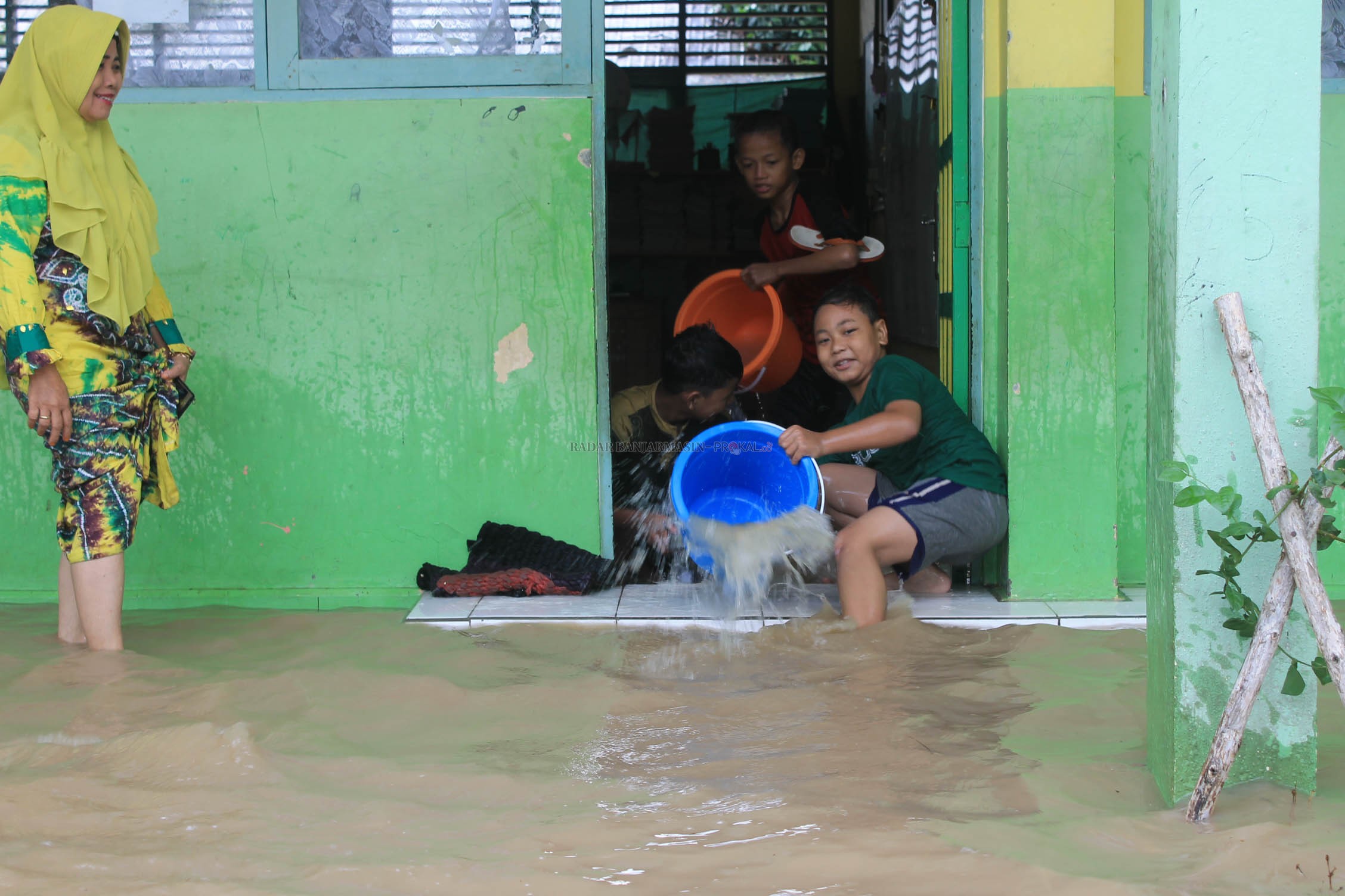 MUSIBAH TAHUNAN: Siswa SDN 1 Kupang di Tapin membuang air dari ruangan kelas mereka. | FOTO: RASIDI FADLI/RADAR BANJARMASIN