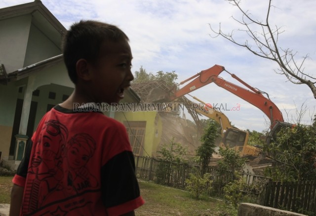 BERTERIAK: Seorang anak menyaksikan proses eksekusi rumah oleh alat berat ekskavator pada Rabu (19/2) di kawasan Landasan Ulin Barat Kecamatan Landasan Ulin Banjarbaru. Eksekusi ini akan merobohkan 11 rumah warga yang dilakukan oleh pihak Pengadilan Neger