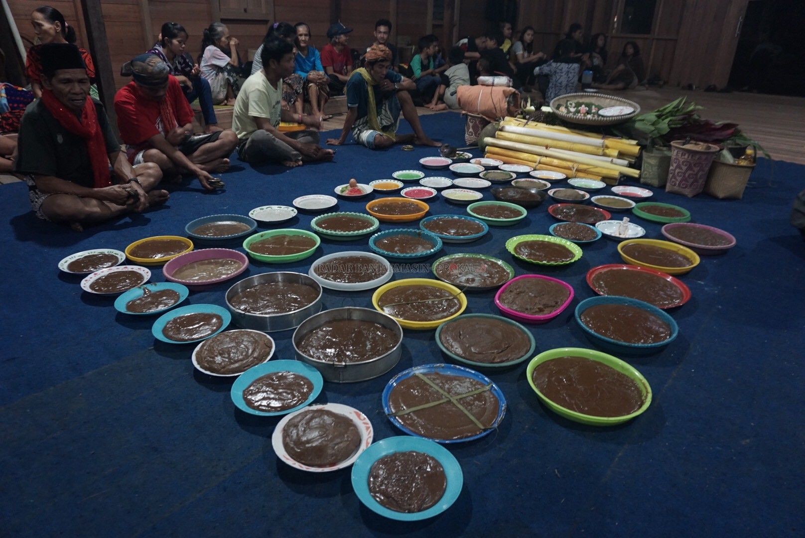PENGHULU ADAT: Balian (memakai penutup kepala) duduk di samping sesaji, sebelum dimulainya ritual. | FOTO: WAHYU RAMADHAN/RADAR BANJARMASIN