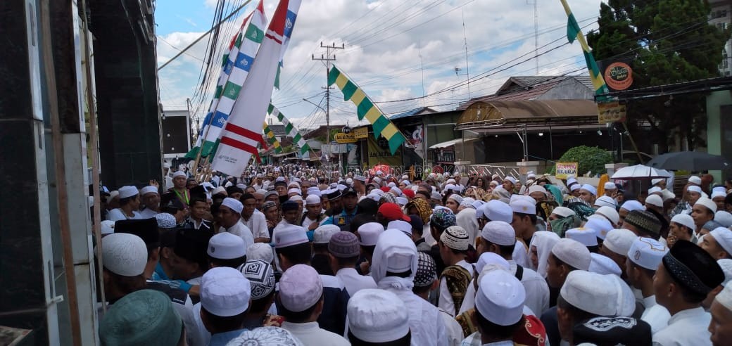 SESAK DAN PANAS : Ratusan Jemaah tertahan di pintu gerbang masuk kompleks Ar Raudah Sekumpul setelah kawasan kompleks hampir over kapasitas menampung jemaah. | Foto : Muhammad Amin/Radar Banjarmasin.