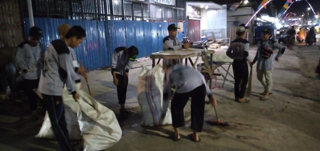Santri Kapuh menyapu dan mengumpulkan sampah pasca Haul sejak dini hari. Tugasnya disambung lagi Senin dini hari. | Foto: Muhammad Amin/Radar Banjarmasin