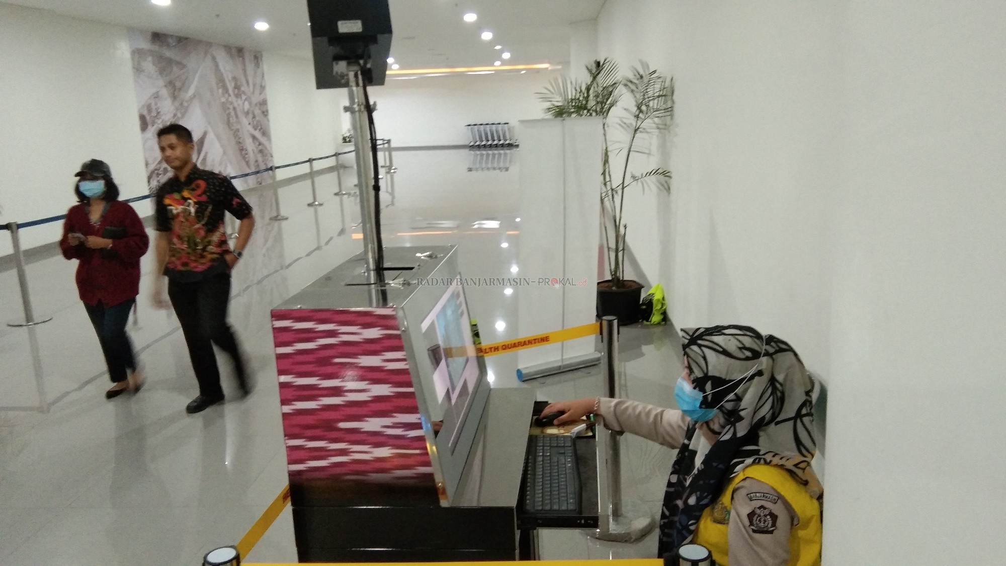 AWASI: Petugas Kantor Kesehatan Pelabuhan (KKP) Banjarmasin menggunakan alat Thermal Scanner atau pemindai suhu tubuhbagi para penumpang yang tiba di terminal kedatangan Bandara Syamsudin Noor. | FOTO: SUTRISNO/RADAR BANJARMASIN