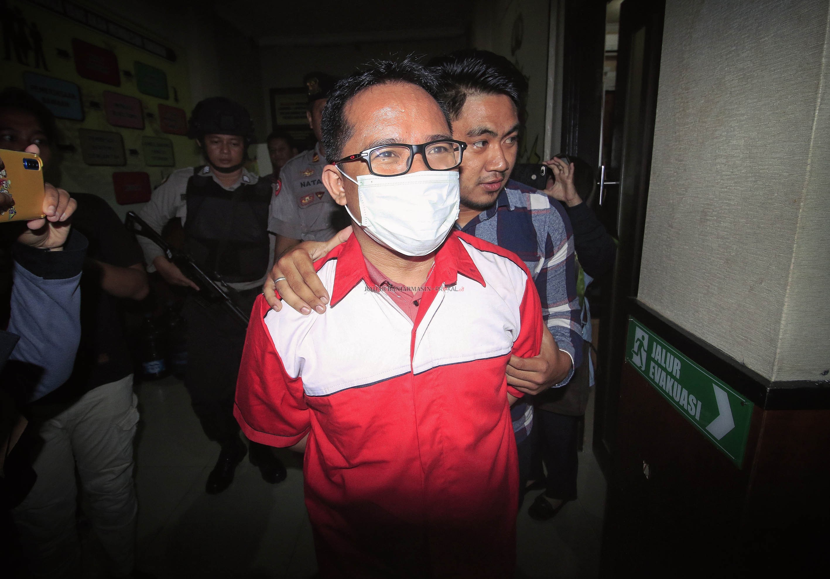 CEPAT DISIDANGKAN: Mantan Ketua KPU Banjarmasin, Gusti Makmur saat digelandang aparat menuju ruang tahanan Mapolres Banjarbaru usai ditetapkan sebagai tersangka.  | DOK/RADAR BANJARMASIN