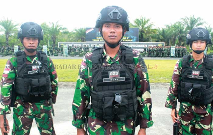 POSISI SIAP: Sersan Satu Rubyanto (tangah) di dampingi dua rekannya, prajurit Batalyon Infanteri 623/BWU usai upacara pengecekan kelengkapan Satgas Pamtas Operasi Perbatasan RI-MLY di Lapangan Upacara Markas Batalyon 623/BWU.