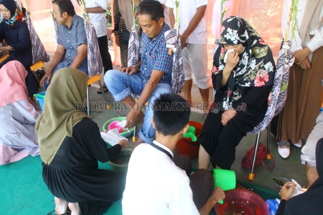 TRADISI UNIK: Para siswa SMAN 2 Banjarmasin mencuci dan mencium kaki orang tua masing-masing untuk minta rida mengikuti UNBK. | Foto: Maulana/Radar Banjarmasin