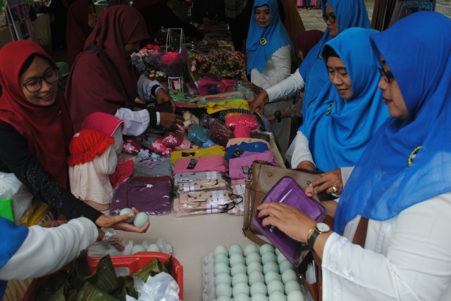 BERBELANJA: Para ibu-ibu berbelanja di bazar Badan Kontak Majelis Taklim (BKMT) Kota Banjarbaru yang dirangkai dengan peringatan Isra Mikraj di Masjid Jami Hidayatul Muhajirin, kemarin (14/3). | FOTO: SUTRISNO/RADAR BANJARMASIN