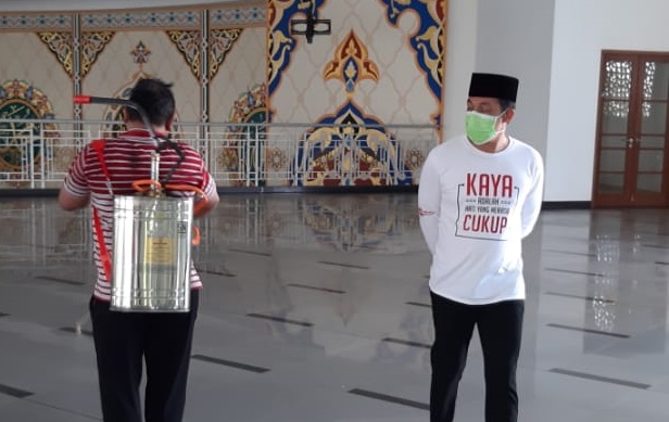 SEKDA AWASI PENYEMPROTAN: Sekda Tanbu H Rooswandi Salem (kanan) ikut mengawasi penyemprotan disinfektan di Masjid Agung Nurussalam, Minggu (15/3) siang. (Foto Sekda For Radar Banjarmasin).