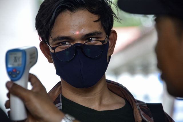 PERIKSA: Petugas memeriksa temperatur pengunjung di sebuah pusat perbelanjaan. Maraknya virus corona membuat pemerintah di Indonesia mencadangkan anggaran untuk pengendalian. | FOTO: CHAIDEER MAHYUDIN/AFP