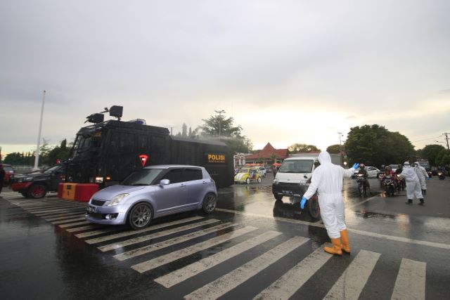 SEMPROT DISINFEKTAN: Personel Satuan Brimob Polda Kalsel melakukan penyemprotan cairan disinfektan di wilayah Banjarbaru, kemarin. | FOTO: MUHAMMAD RIFANI/RADAR BANJARMASIN