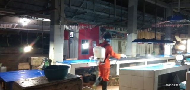 PENYEMPROTAN DISINFEKTAN: Petugas dari Dinas Kesehatan Tanbu melakukan penyemprotan cairan disinfektan di pasar ikan Kecamatan Kusan Hilir. (Foto Diskominfo Tanbu For Radar Banjarmasin).