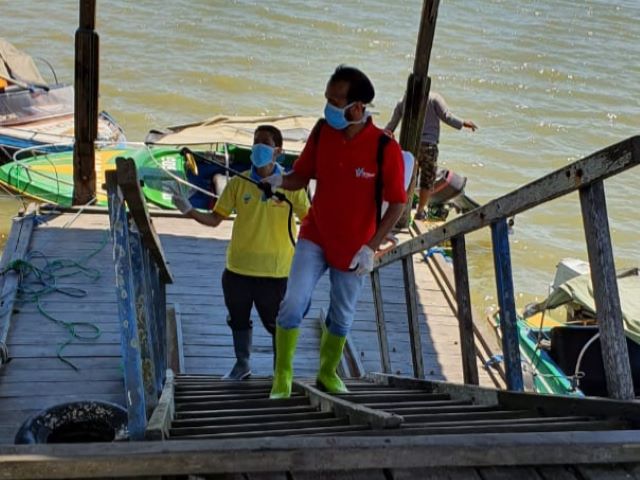 MELAKUKAN PENYEMPROTAN: Petugas Dinas Kesehatan melakukan penyemprotan cairan disinfektan di Pelabuhan Speed Batulicin di Desa Sejahtera Kecamatan Simpang Empat. (Foto Diskominfo Tanbu For Radar Banjarmasin).