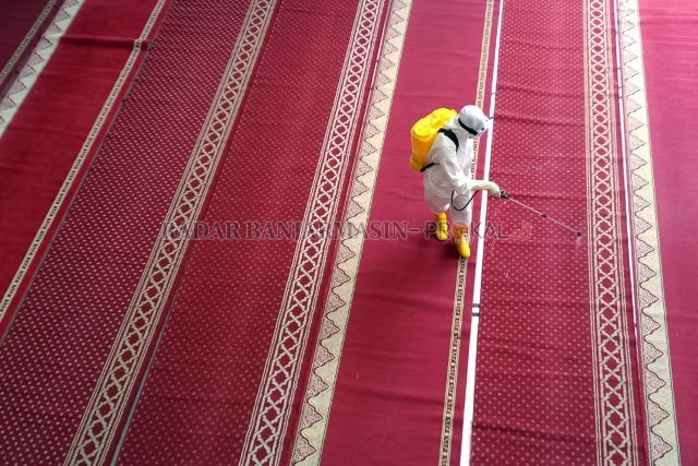 DISINFEKSI: Petugas kepolisian menyemprotkan cairan disinfektan ke tempat ibadah di lingkungan SMA Al Mazaya Islamic School di Jalan Cempaka Besar. | FOTO: ENDANG SYARIFUDDIN/RADAR BANJARMASIN