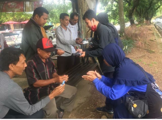 EDUKASI DI JALAN: Relawan Radar Banjar Peduli memeragakan cara mencuci tangan dengan bersih dan benar untuk mencegah penularan Covid-19 kepada para pekerja di jalanan. | FOTO: RBP