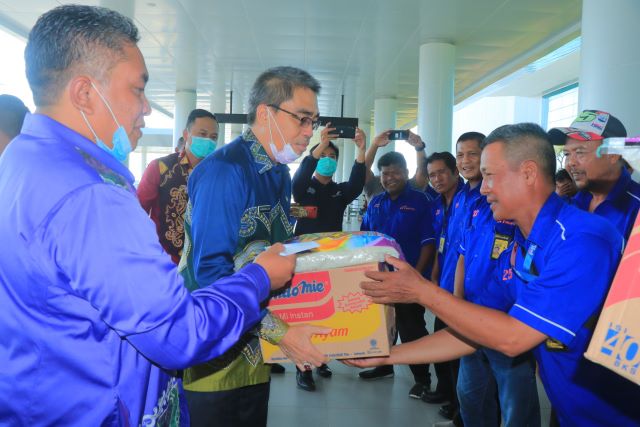 SERAHKAN BANTUAN: Walikota Banjarbaru H Nadjmi Adhani bersama Wakil Walikota Banjarbaru Darmawan Jaya Setiawan saat menyerahkan bantuan CSR berupa sembako dari Bank Kalsel kepada para petugas porter barang di Bandara Internasional Syamsudin Noor, Kamis (2