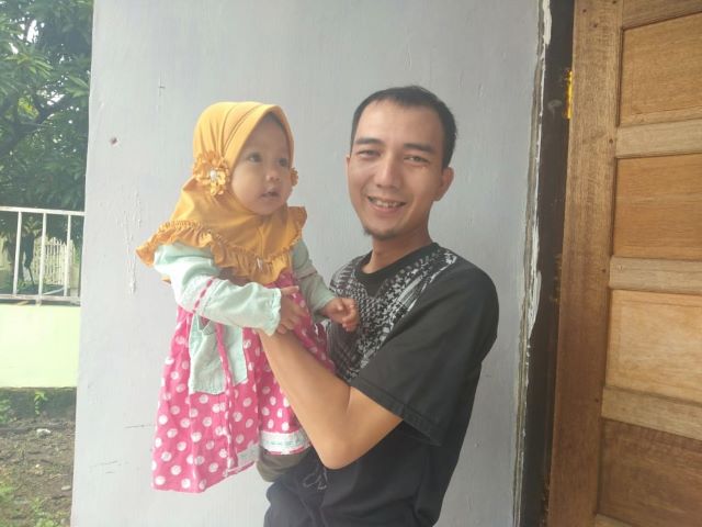 Syaukani Chandrawinata saat menggendong anaknya; Fatimah Az-Zahra saat dikunjungi Radar Banjarmasin, kemarin. | FOTO: SUTRISNO/RADAR BANJARMASIN