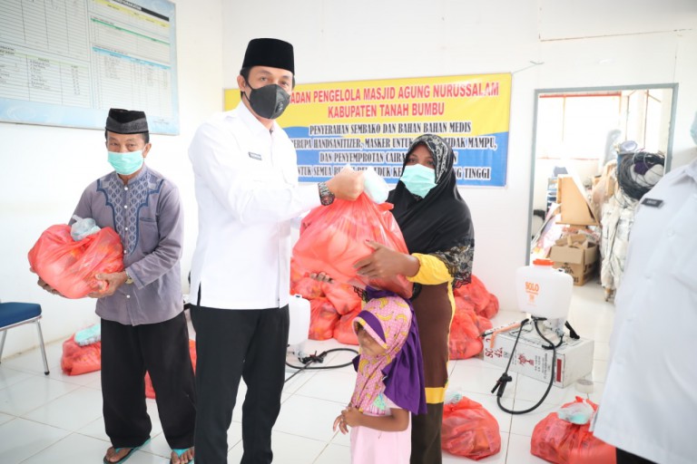 MENYERAHKAN : Sekda Tanbu H Rooswandi Salem menyerahkan bantuan sembako kepada warga kurang mampu.