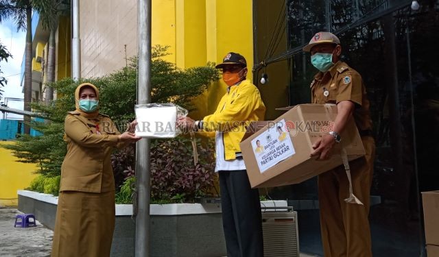 BANTUAN BERHARGA: Ketua Harian DPD Golkar Kalsel H Supian HK menyerahkan bantuan baju hazmat kepada Dirut RS Ulin dr Suciati.