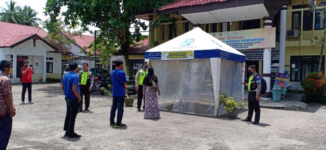 PENCEGAHAN : Warga harus masuk bilik sterilisasi saat bayar PKB di UPPD Kandangan. | FOTO: SALAHUDIN/RADAR BANJARMASIN