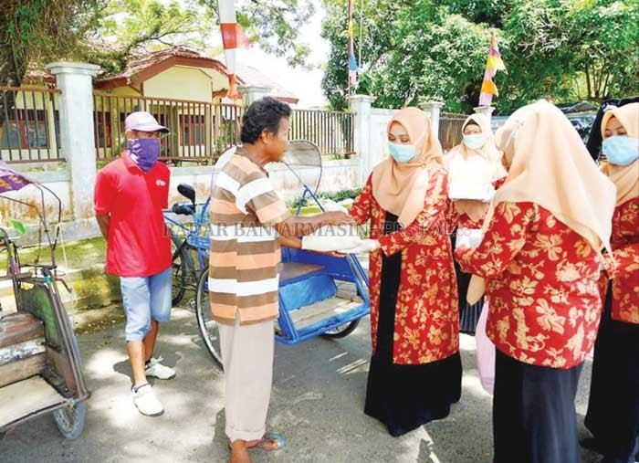 BERBAGI: Ketua DWP Tanbu Hj Mulyawati memberikan bantuan kepada warga yang berprofesi sebagai tukang becak di wilayah Kecamatan Kusan Hilir, Rabu (8/4). (Foto Diskominfo Tanbu For Radar Banjarmasin).