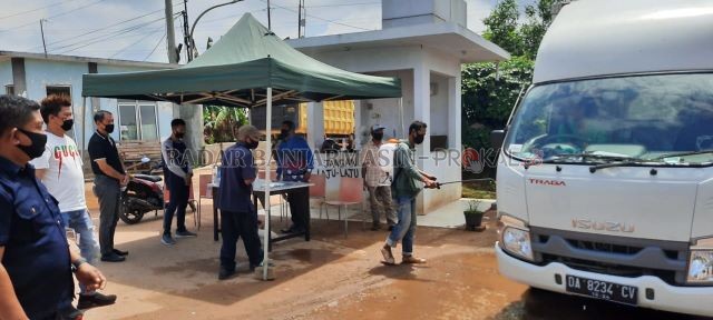 DISEMPROT: Setiap angkutan logistik yang hendak memasuki komplek pergudangan Basirih, harus melewati penyemprotan disinfektan dulu. | FOTO: MUHAMMAD OSCAR FRABY/RADAR BANJARMASIN