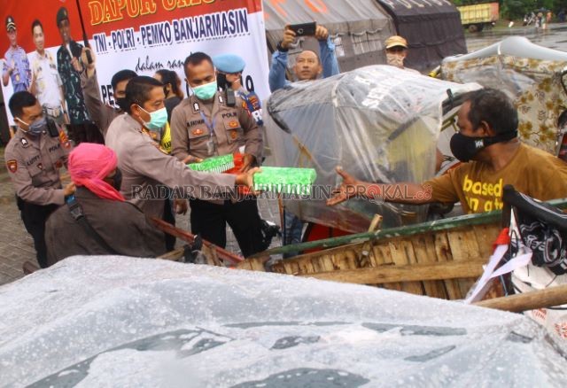 DAPUR UMUM: Kapolresta Banjarmasin menyerahkan nasi kotak pada penarik becak di sekitar Taman Kamboja, Jalan Anang Adenansi. | Foto: Maulana/Radar Banjarmasin