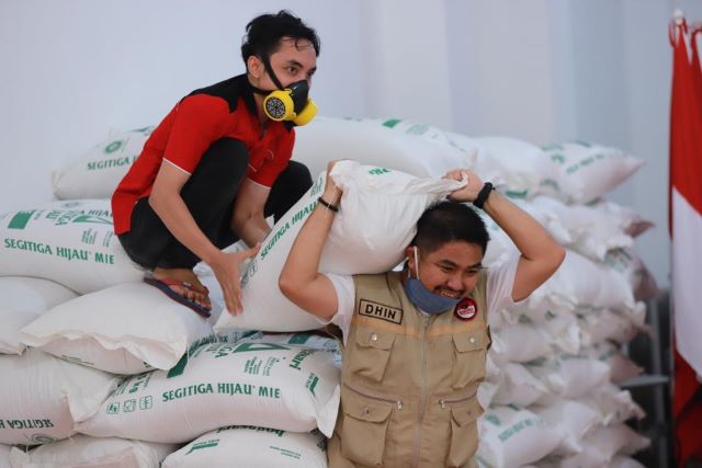 SOLIDARITAS: Kader DPD PDIP Kalsel bergotong-royong mengangkat karung beras untuk kemudian dibagikan kepada masyarakat.
