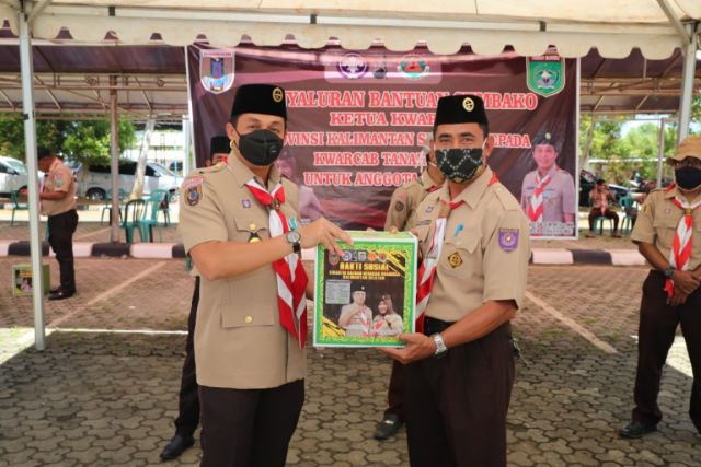 BAGIKAN BANSOS: Sekda Tanbu H Rooswandi Salem yang juga Ketua Kwartir Cabang (Kwarcab) Tanbu (kiri) membagikan bantuan sosial (Bansos) berupa sembako untuk masyarakat terdampak pandemi Covid-19 di 10 kecamatan. (Foto Diskominfo Tanbu For Radar Banjarmasin