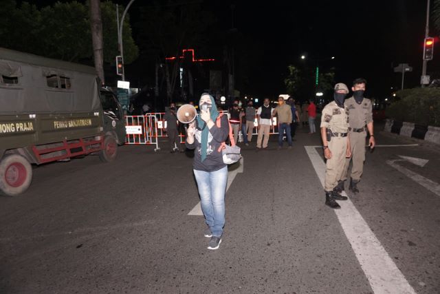 SURUH PULANG: Menggunakan megafon, petugas menyuruh pengendara untuk balik kanan. Selama penerapan jam malam, perbatasan kota Banjarmasin dijaga ketat. | FOTO: WAHYU RAMADHAN/RADAR BANJARMASIN