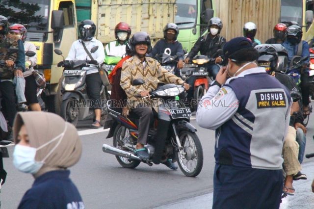 KAI, MASKER PIAN MANA?: Petugas jaga di Posko PSBB Jalan Ahmad Yani kilometer 6 mencegat seorang pengendara yang tidak memakai masker. Karena kasihan untuk menyuruh kembali, akhirnya petugas memberikan jatah maskernya. | FOTO: MAULANA/RADAR BANJARMASIN